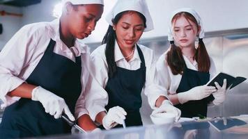 gruppo di studentesse avendo divertimento apprendimento per cucinare. femmina studenti nel un' cucinando classe. foto