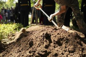 uomo scava grave. lavoratore con pala. cumulo. foto