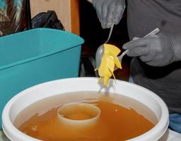 lavaggio il plastica parti di un' molto sporco cucina scarico fan nel un acquoso soluzione di sodio idrossido. un' uomo lavori nel protettivo guanti. foto