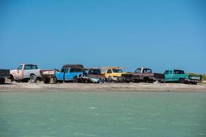 abbandonato macchine su il spiaggia vicino il mare foto