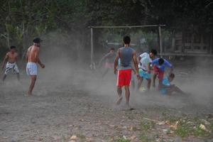 gili asahan, Indonesia - agosto, 22 2016 - ragazzi siamo giocando calcio a tramonto su un' palma albero campo vicino il spiaggia foto