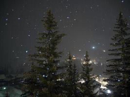 nevicando a notte nel dolomiti montagne foto