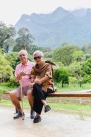 verticale di asiatico anziano coppia sedersi su un' panchina su vacanza all'aperto. foto