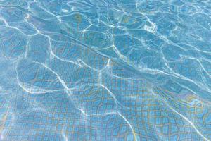 bellissimo chiaro blu acqua con onde e raggi nel il mare. estate vacanza e piscina. nuoto piscina, estate all'aperto sport, ricreativo attività sfondo concetto foto