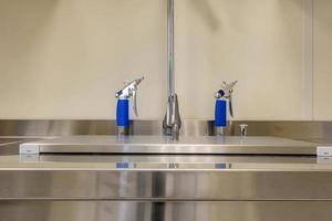 gomito dispenser sapone e antisettico o disinfettante a parete per la disinfezione delle mani e rubinetto dell'acqua lavabo con rubinetto bagno o clinica foto