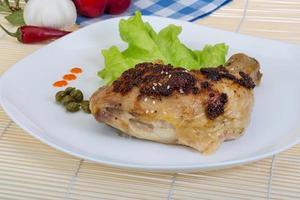 arrostito pollo gamba su il piatto e di legno sfondo foto