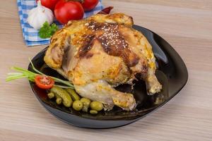 grigliato pollo su il piatto e di legno sfondo foto