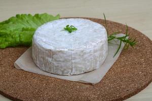 Brie formaggio su di legno tavola e di legno sfondo foto