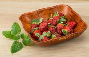 fresco fragola nel un' ciotola su di legno sfondo foto