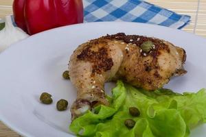 arrostito pollo gamba su il piatto e di legno sfondo foto