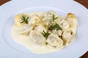 gnocchi russi sul piatto e sullo sfondo di legno foto