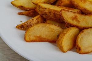 fritte Patata su il piatto e di legno sfondo foto