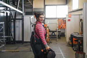 un' ritratto di un' donne saldatore Tenere un' casco e preparazione per un' Lavorando giorno nel il metallo industria foto