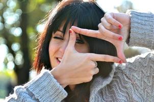 giovane donna fingendo per vedere attraverso un' lente foto