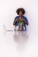 africano americano donna seduta su pavimento con il computer portatile foto