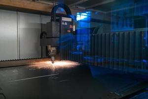 scintille volare su macchina testa per metallo in lavorazione laser metallo su metallurgico pianta sfondo. produzione finito parti per settore automobilistico produzione concetto foto