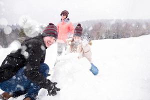 gruppo di giovane persone fabbricazione un' pupazzo di neve foto