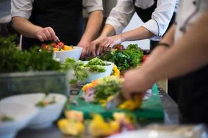 cuochi di squadra e chef che preparano i pasti foto