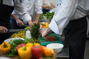 cuochi di squadra e chef che preparano i pasti foto