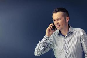 uomo d'affari su il Telefono contro il parete. foto