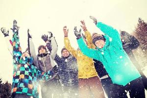 gruppo di giovane persone lancio neve nel il aria foto