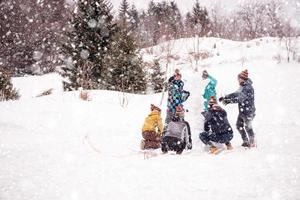 gruppo di giovane persone fabbricazione un' pupazzo di neve foto