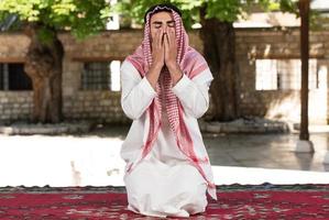 l'uomo musulmano sta pregando nella moschea foto
