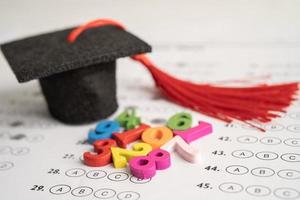 numero di matematica colorato con cappello di laurea e matita sullo sfondo del foglio delle risposte, studio dell'istruzione apprendimento della matematica concetto di insegnamento. foto