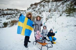 famiglia scandinava con bandiera svedese nel paesaggio svedese invernale. foto