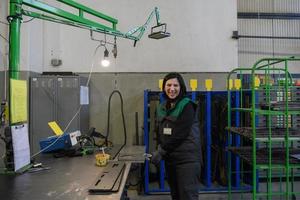 un' donna Lavorando nel il moderno metallo produzione e in lavorazione industria saldature il Prodotto e prepara esso per un' cnc macchina foto