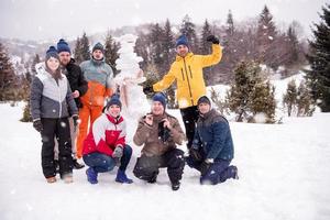 gruppo portait di giovane persone in posa con pupazzo di neve foto