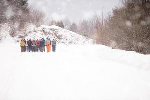 gruppo di giovane persone a piedi attraverso bellissimo inverno paesaggio foto