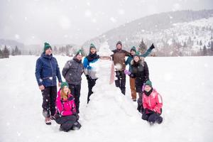 gruppo portait di giovane persone in posa con pupazzo di neve foto