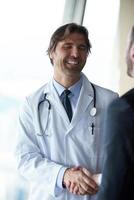 medico stretta di mano con un' paziente foto