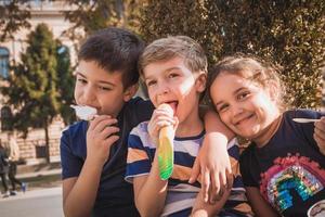 ritratto di contento bambini mangiare ghiaccio crema. foto