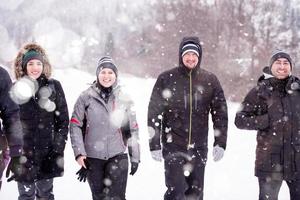 gruppo di giovane persone a piedi attraverso bellissimo inverno paesaggio foto