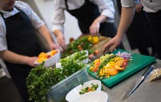 cuochi di squadra e chef che preparano i pasti foto