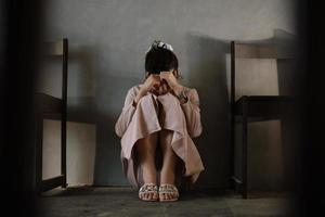 donna sedersi depressione buio dai capelli pensieroso occhiata in piedi di finestra e ansia copia spazio. foto