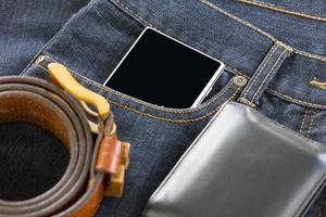 portafoglio e smartphone su jeans denim foto