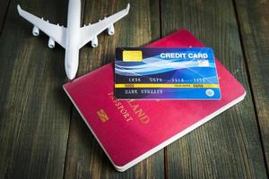 carta di credito messa sul passaporto sul tavolo di legno foto