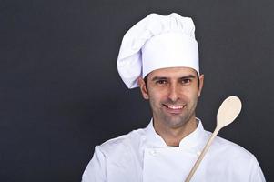 portriat del cuoco con cucchiaio su sfondo scuro foto