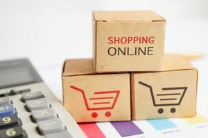 shopping online, scatola del carrello sulla calcolatrice, import export, commercio finanziario. foto