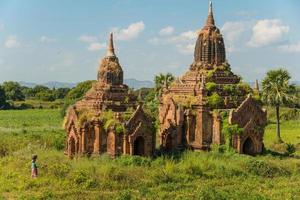 il scenario Visualizza di vecchio tempio nel Bagan archeologia luogo con Locale persone camminare nel agricoltura campo. foto