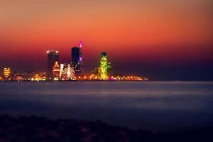 notte città batumi blu ora con lungomare panorama. batumi, adjara, Georgia. panorama di illuminato ricorrere cittadina a tramonto. nero mare, Ferris ruota e alfabeto Torre foto