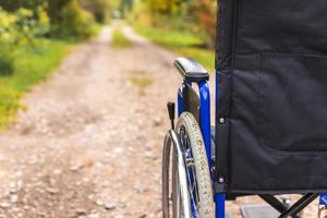 sedia a rotelle vuota in piedi sulla strada in attesa di servizi per i pazienti. sedia a rotelle per persone con disabilità parcheggiate all'aperto. accessibile a persone con disabilità. concetto medico sanitario. foto