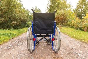 sedia a rotelle vuota in piedi sulla strada in attesa di servizi per i pazienti. sedia a rotelle per persone con disabilità parcheggiate all'aperto. accessibile a persone con disabilità. concetto medico sanitario. foto