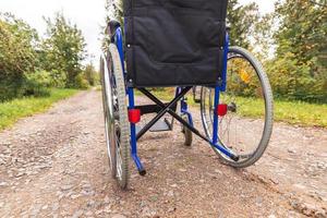 sedia a rotelle vuota in piedi sulla strada in attesa di servizi per i pazienti. sedia a rotelle per persone con disabilità parcheggiate all'aperto. accessibile a persone con disabilità. concetto medico sanitario. foto