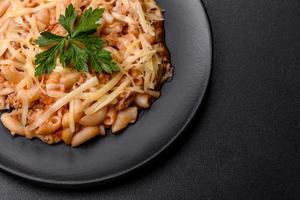 gustoso appetitoso classico italiano pasta con pomodoro salsa e formaggio su piatto su buio sfondo foto