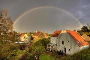 città di campagna con arcobaleno dopo la pioggia foto