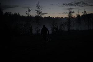uomo nel nebbia su lago. presto mattina nel boschi. foto